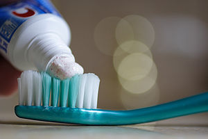 Putting toothpaste on a toothbrush. The toothp...